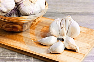 Garlic and garlic cloves on a wooden cutting board