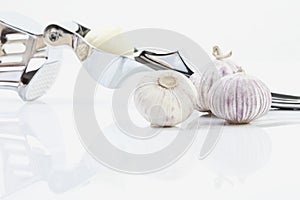 Garlic and garlic press against white background