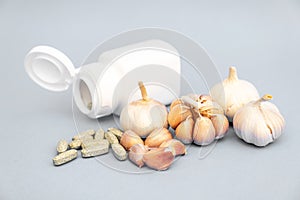 Garlic, Garlic tablet, White medicine bottle on gray background. Alternative medicine, herbal treatment concepts