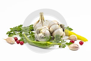 Garlic heads, fresh parsley leaves, hot peppers, berries isolated on white background