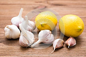 Garlic and lemon on a wooden table. Alternative medicine, treatment with folk remedies. Lower cholesterol