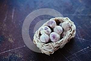 Garlic in a light wicker basket on a dark background