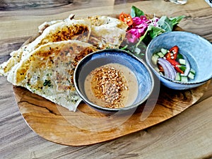 Garlic naan roti lightly grilled flat bread with peanut satay sauce and garden salad and cucumber vinegar relish