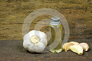 Garlic Oil in bottle on wooden background.