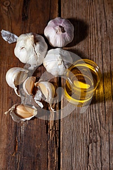 Garlic oil and garlic on a wooden table