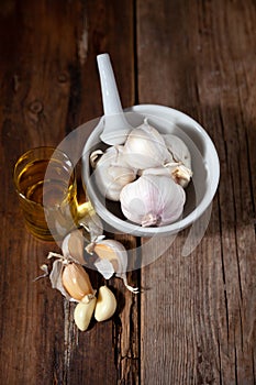 Garlic oil and garlic on a wooden table