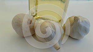 Garlic oil on white background, up healthy food falls poured slow-motion shooting