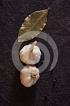 Garlic, onion, bay leaf, black pepper on textile background. Food background. Garlics. sliced garlic, garlic clove, garlic bulb.
