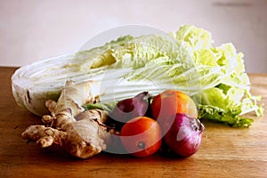 Garlic, onion, ginger, tomato and cabbage on a chopping board