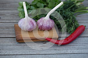 Garlic, peppers and herbs on a wooden background
