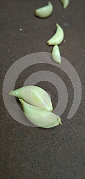 Garlic pieces on brown background