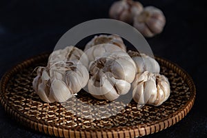 Garlic is placed on the black table in the kitchen, preparing for cooking