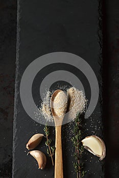 Garlic powder and cloves on black slate board