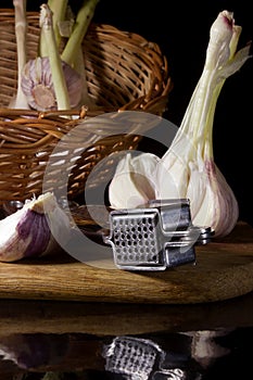 Garlic press and cloves of garlic