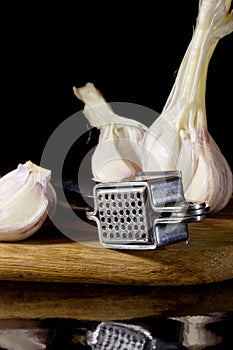 Garlic press and cloves of garlic