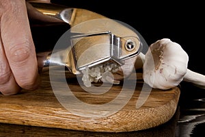 Garlic press and cloves of garlic