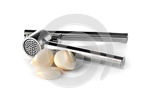 Garlic press and cloves on white backgroun