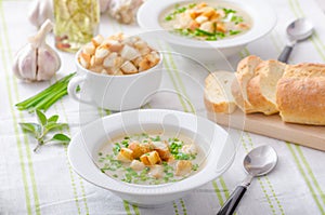 Garlic soup with croutons, spring onions and chives