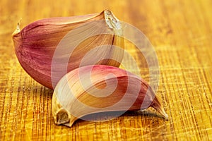 Garlic. Two Purple garlic cloves isolated on a wooden board