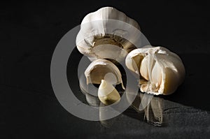 Garlic whole bulb and peeled cloves black backdrop