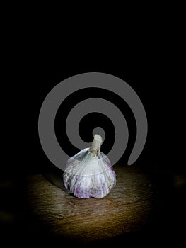 Garlic on wooden board on dark background