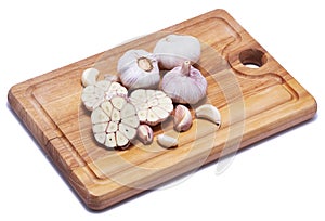 Garlic on wooden chopping board isolated on white background