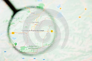 Garmisch-Partenkirchen city in Germany, Bavaria visualization illustrative concept on display screen through magnifying