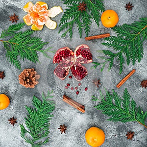 Garnet fruit, mandarin. cinnamon, anise and winter tree on dark background. Christmas concept. Flat lay. Top view