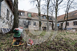 gartenzwerg mit kopf auf dem boden bei verlassenen haus