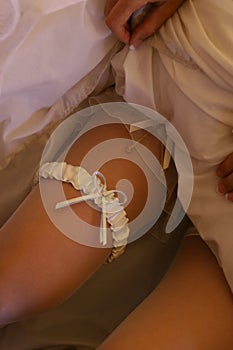 Garter on the bride`s leg