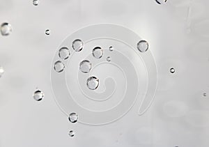 Gas bubbles of refreshing sparkling water attached to the glass on bright background with copy space