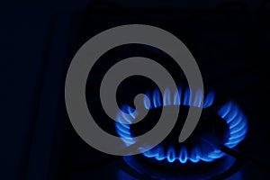 Gas burner with burning flame in darkness. Space for text