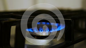 Gas burner. Gas source, a flame burns on a gas stove, blue flames on a black background - with copy space. Blue fire