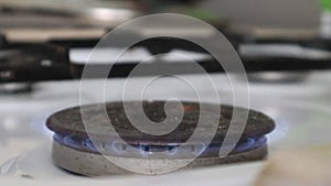 Gas burner on a kitchen stove for cooking with a burning propane fire. Natural gas ignites with a blue flame. Natural gas concept.