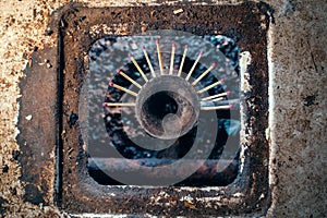 Gas burner of an old dirty kitchen stove with matches stuck in the jets. Lack of gas in the gas pipeline and the search for a