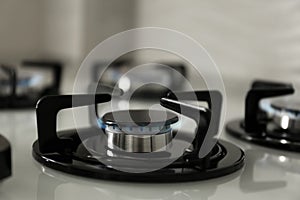 Gas burners with blue flame on modern stove