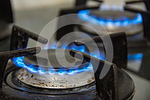 Gas burning out with blue flames on the burners of a gas cooker