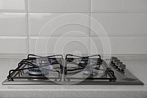 Gas cooktop with burning blue flames in kitchen