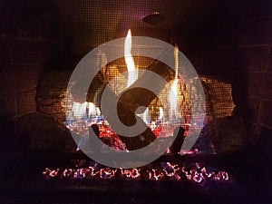 Gas fireplace with flame and fire and logs and metal grate