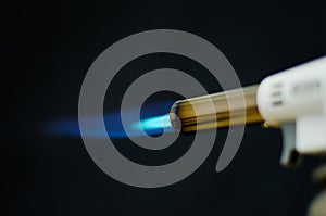 Gas flame gun torch blue fire butane white background