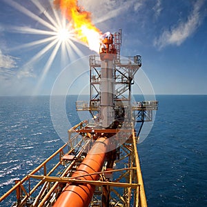 The gas flare on the offshore oil rig platform. Gas flare boom at an oil refinery. Concept of environment, pollution and global