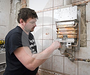 Un forno a gas specializzato, idraulico l'uomo, regolare in un bagno di recente costruzione.