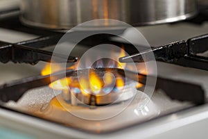 Gas kitchen stove with fire close-up, gas cost concept for household