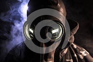 Gas mask with clouds of smoke on a dark background. Sign of radioactive contamination. Means for radiation protection. Danger of