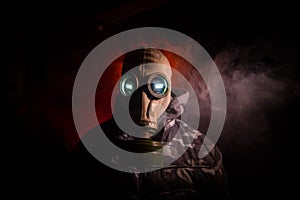 Gas mask with clouds of smoke on a dark background. Sign of radioactive contamination. Means for radiation protection. Danger of