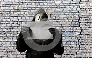 Gas mask. Man wearing a gas mask on his face and holding white paper