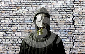 Gas mask. Man wearing a gas mask on his face and the wall behind him with copy space