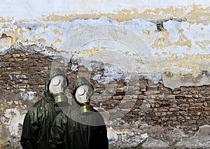 Gas masks. Two people with gas masks and brick wall behind with copy space