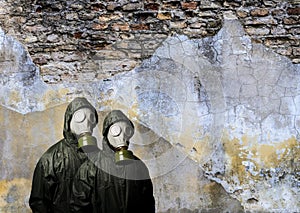 Gas masks. Two people with gas masks and brick wall behind with copy space