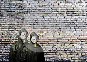 Gas masks. Two people with gas masks and brick wall behind with copy space